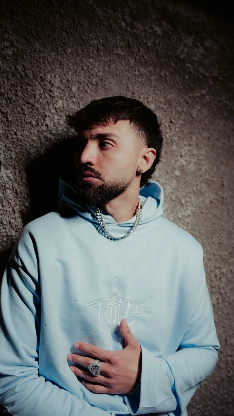 Portrait in a light-blue hoodie looking to one side.