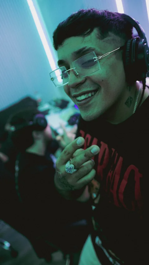 Portrait with clear glasses in a green-lit studio.