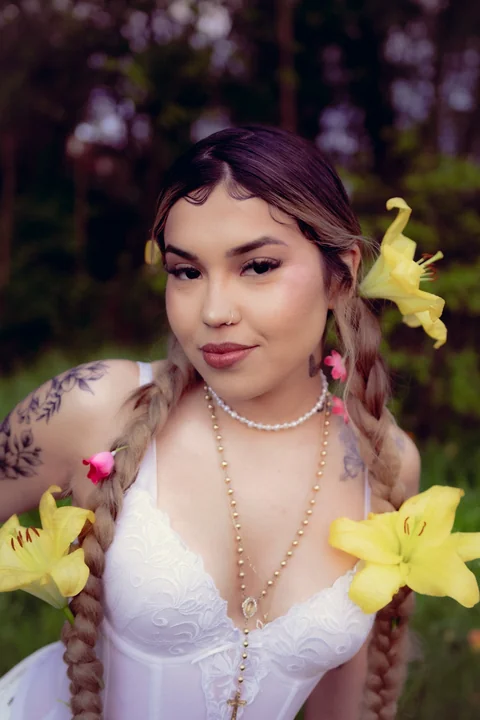 Portrait among greenery with yellow flowers in the hair.