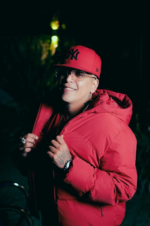 Persona con chaqueta y gorra rojas en una escena nocturna.